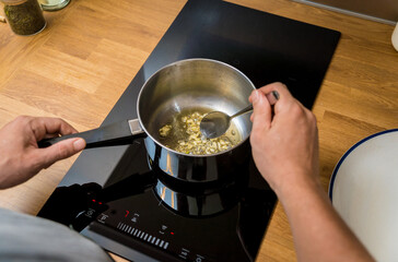 Chef at the kitchen preparing healthy quinoa bowl with avocado