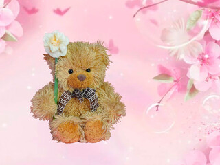 A teddy bear holds a daffodil flower in his hands, a beautiful jar on his neck, on a pink...