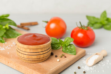 Delicious ketchup with spices and tomatoes on wooden table