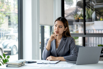 Businesswomen bookkeeper use laptop analysis the graph for Setting challenging business goals and ready to achieve target at home office