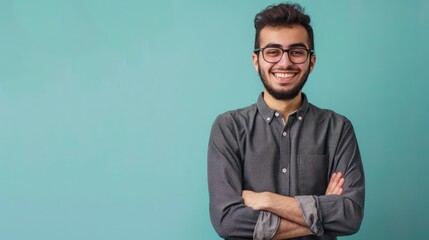 Obraz premium Smiling confident arab young man, male student, professional employee or programmer standing isolated on blue background. Happy handsome ethnic guy wearing shirt and glasses portrait. 