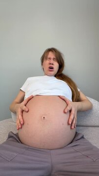 Anxious nervous pregnant woman feeling bad and stroking her belly