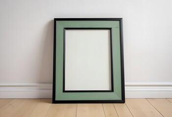 A black picture frame on a wooden floor against a white wall