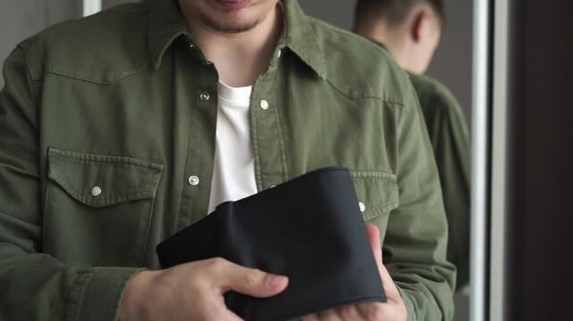 A man holds a wallet without money.
Poverty, finance, money