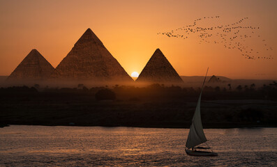 Giza pyramid Complex by the Nile at amazing sunset - Fishermen casting their fishing nets on a boat in Nile river at amazing sunset - Egypt
