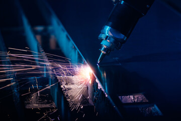 Bevel cutting metal from CNC laser, sparks fly. Blue steel color, modern industrial technology