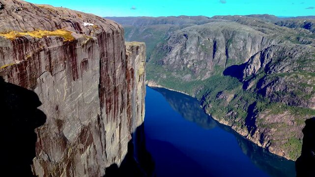 The stunning panorama of Lysefjord from Preikestolen in Norway features dramatic cliffs over serene waters, making it an ideal spot for travel inspiration and outdoor adventures