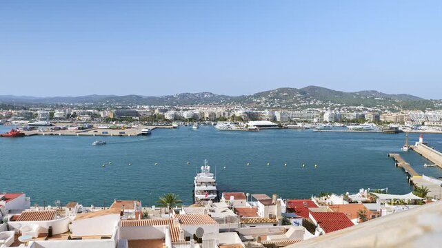 Panoramic footage of the entrance to Ibiza Port, with boats and yachts approaching the port. Ibiza Marina and Talamanca also visible in the distance.