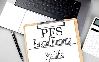PFS word on clipboard on laptop with calculator and pen