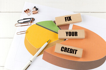FIX YOUR CREDIT word on wooden block on chart background