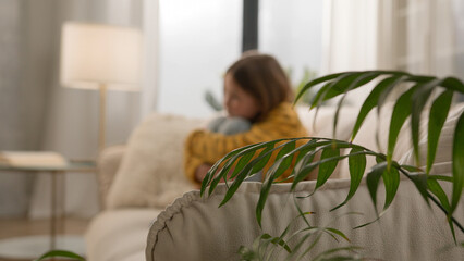 Bored disappointed little Caucasian girl schoolgirl daughter kid hug knees alone home thinking...