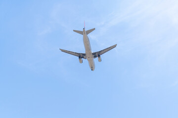 Landing airplane on the background of blue sky