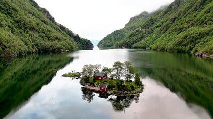 Breathtaking aerial view ofLovrafjorden, Norway, showcasing serene waters and lush greenery. Perfect for travel and nature enthusiasts, red cabin on an Island in the middle of a fjord