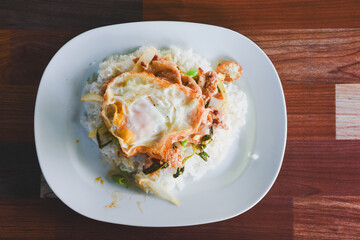 Pork with basil and fried egg on rice is ready to eat on the table.