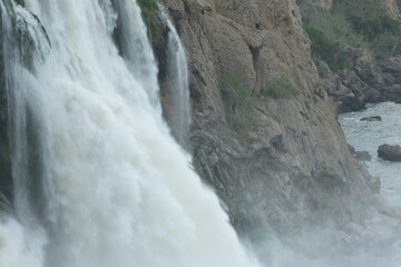 Waterfall flowing towards the sea behind the cliffs
