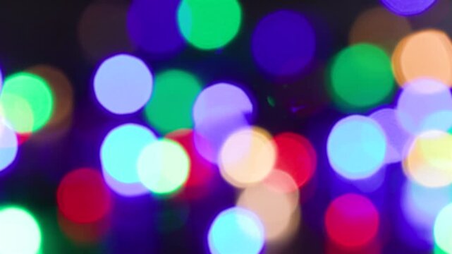 Christmas tree garland. Yellow, green, red and green lights. Defocused image, bokeh effect. Seamless looping