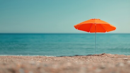 Orange Umbrella on Sandy Beach by the Calm Ocean Under Clear Sky