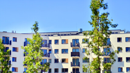 New modern block of flats in green area. Eco apartment building saving energy and fresh air concept. Green tree and new apartment building. The harmony of nature and modernity.