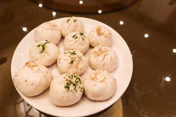 Close up of Chinese Shanghai- style pan-fried meat and vegetables bun bread on a plate with spring...