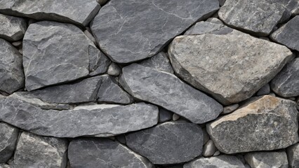 Obraz premium Close-up of a dry stone wall with irregularly shaped gray stones tightly stacked together. The image showcases the rough texture and natural patterns of the stones, ideal for backgrounds