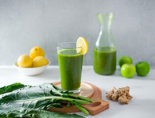 Fototapeta premium Fresh organic green juice made from leafy greens, ginger root, lemon and green apple; raw food diet; copy space
