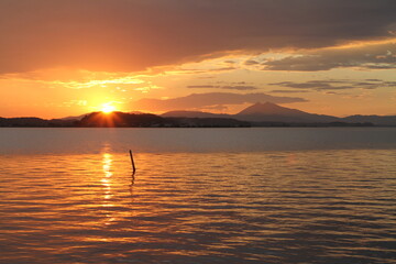Sunset on a lake with the sky and reflection on water turning orange