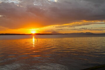 Sunset on a lake with the sky and reflection on water turning orange