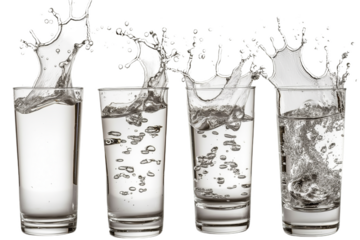 Four glasses of water with splashes of water frozen in time. The glasses are filled with clear water.