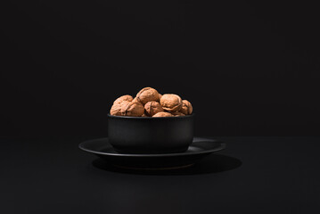 Nueces en un recipiente negro sobre fondo negro