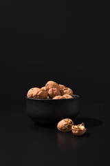Nueces en un recipiente negro sobre fondo negro