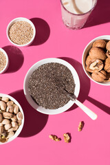 Semillas de chía, sésamo, nueces y pistachos. Frutos secos sobre un fondo rosa. Vista superior