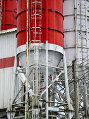 A stationary with pipes outside of a concrete factory