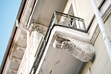 Damaged balcony with cracked plaster corbel, damaged concrete and falling plaster, floor need for repair. Damaged balcony with cracks in reinforced concrete structure © Tricky Shark