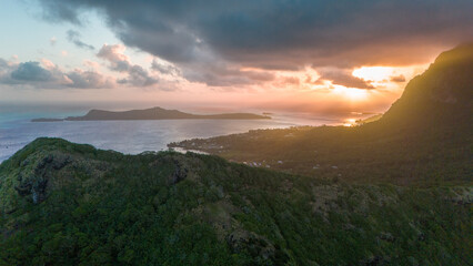Sunset in the sky under low hanging clouds behind the tropical island of Bora Bora in French Polynesia. 