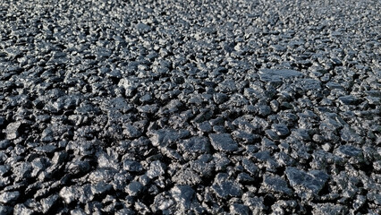 New laid asphalt road, large crushed stone.  Close-up. Background.
