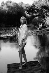 Portrait of a young beautiful blonde long-haired girl in nature. Black and white photo.