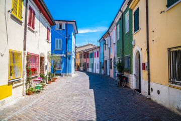 A view down a quiet, deserted, colourful street in the village area of San Giuliano in Rimini,...