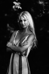 Portrait of a young beautiful blonde long-haired girl in nature. Black and white photo.