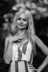 Portrait of a young beautiful blonde long-haired girl in nature. Black and white photo.