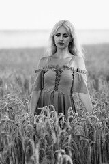 Portrait of a young beautiful blonde long-haired girl in nature. Black and white photo.