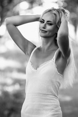 Portrait of a young beautiful blonde long-haired girl in nature. Black and white photo.