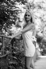 Portrait of a young beautiful blonde long-haired girl in nature. Black and white photo.
