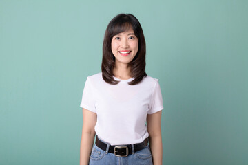 Smiling positive, attractive asian woman in white t-shirt, confident look, green background.