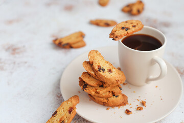 Italian raisin almond biscotti and glass of milk on light background.