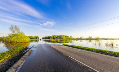 Obraz premium A road is flooded with water and the sky is blue