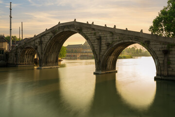 Wanyuan bridge in the morning sun and their reflections in the water. Shuanglinzhen, Nanxun District, Huzhou, Zhejiang, China.