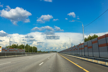 A long, empty highway with a blue sky above