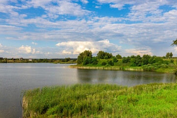 A calm lake with a few trees in the background