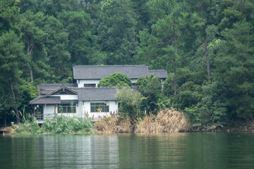 Obraz premium residential building by lake in forest