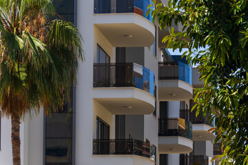 City view on a sunny day. Modern building and houses against the blue sky.
